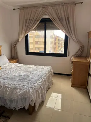 a bedroom with a bed and a large window at Résidence Oslo in Khemisset