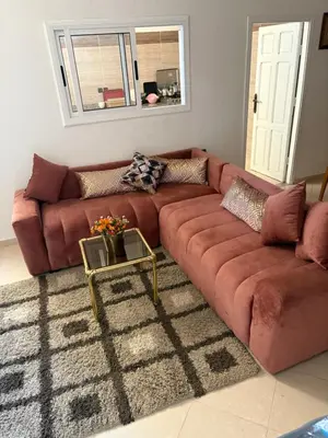 a brown couch in a living room with a table at Résidence Oslo in Khemisset