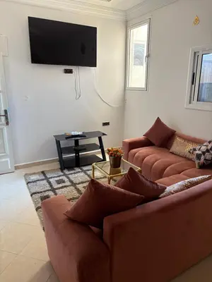 a living room with two couches and a flat screen tv at Résidence Oslo in Khemisset