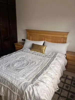 a large bed with a white comforter and gold pillow at Résidence Oslo in Khemisset