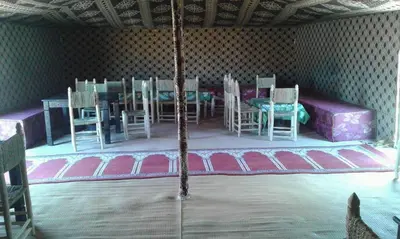 a room with a table and chairs on a stage at chez zakaria luxury tent camp merzouga in Erfoud
