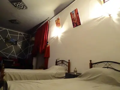 a bedroom with two beds and two lights on the wall at el habib in Fès