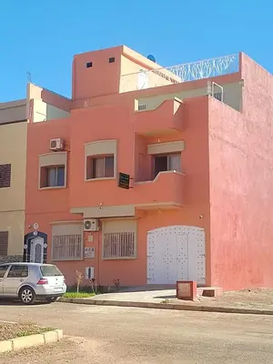 a pink building with a car parked in front of it at Maison d'hôte Najah 2 in Khenifra