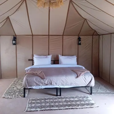 a bedroom with a bed in a tent at Serenity desert luxury Camp in Merzouga