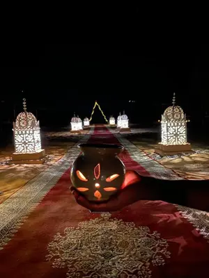 a vase with a face on it on a floor with lights at Luxury Merzouga stars camp in Merzouga