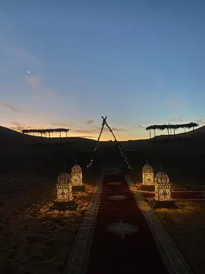 a group of lights in the desert at sunset at Luxury Merzouga stars camp in Merzouga