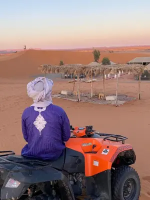 a person riding a quad bike in the desert at Luxury Merzouga stars camp in Merzouga