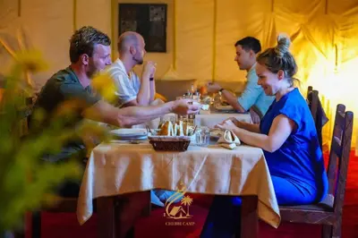 a group of people sitting at a table at Merzougadreamcamp in Merzouga