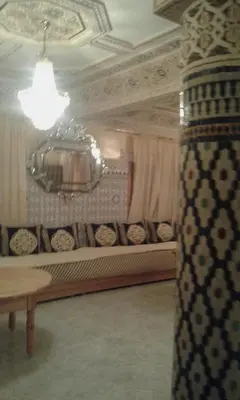 a living room with a couch and a chandelier at FeS in Fès