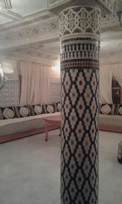 a column in the middle of a room with couches at FeS in Fès