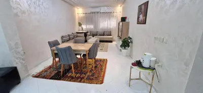 a dining room with a table and chairs at Appartement de charme in Fès