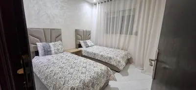 a bedroom with two beds and a window at Appartement de charme in Fès
