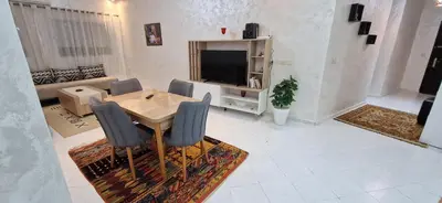 a living room with a wooden table and chairs at Cozy apartment in Fès