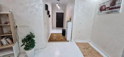 a hallway with a white hallway with a plant in it at Cozy apartment in Fès