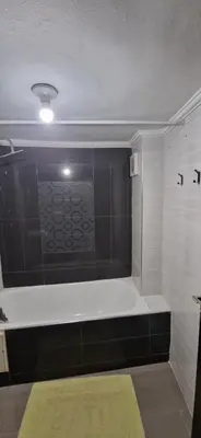 a bath tub in a bathroom with a green rug at Cozy apartment in Fès