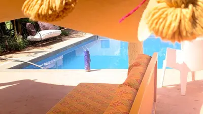 a view of a swimming pool with a couch and a chair at Riad Belgika Marrakech in Ourika