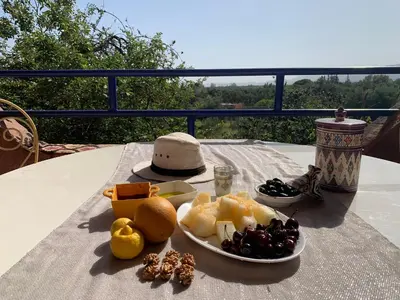 a table with a plate of food on a table at Riad Belgika Marrakech in Ourika