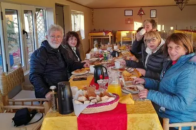 a group of people sitting at a table eating food at Merzouga Berber Luxury Camp in Merzouga