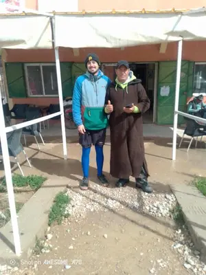 two men standing next to each other under a tent at Ait hani in Tinerhir
