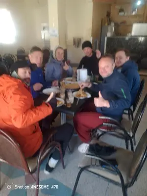 a group of people sitting at a table eating food at Ait hani in Tinerhir