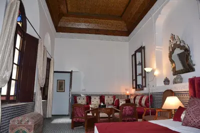 a living room with chairs and a table in a room at Dar Al Batoul in Fès