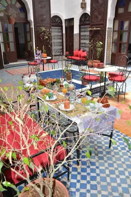a patio with tables and chairs with food on them at Dar Al Batoul in Fès
