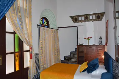 a bedroom with a bed and a dresser and a window at Dar Al Batoul in Fès