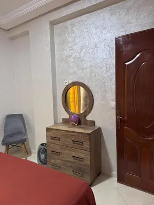 a bedroom with a dresser with a mirror on it at Home Louah Apartment Retreat in Oulad Tayeb