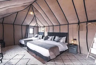 a bedroom with two beds in a tent at Merzouga Queen Luxury Camp in Merzouga