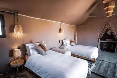 a bedroom with two beds in a tent at Merzouga Queen Luxury Camp in Merzouga