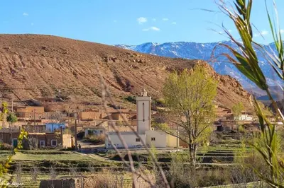 a small village with a church in front of a mountain at Gîte flilou in Midelt
