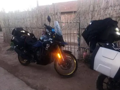 two motorcycles are parked next to a fence at Gîte flilou in Midelt