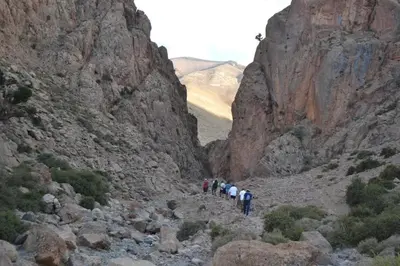 a group of people walking through a rocky canyon at Gîte flilou in Midelt