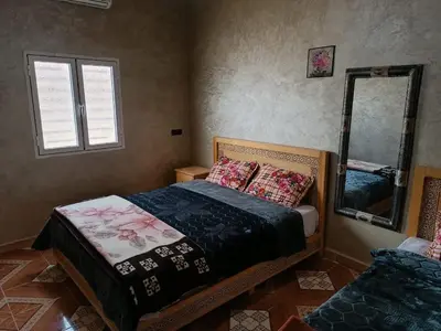 a bedroom with a bed and a mirror at Merzouga camp activités in Merzouga