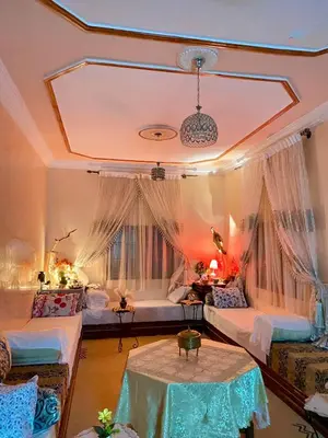 a room with two beds and two tables in it at The Big Moon in Skoura