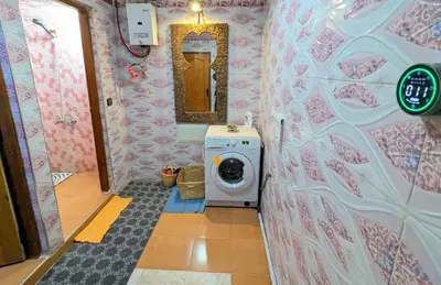 a bathroom with a washing machine and a mirror at The Big Moon in Skoura