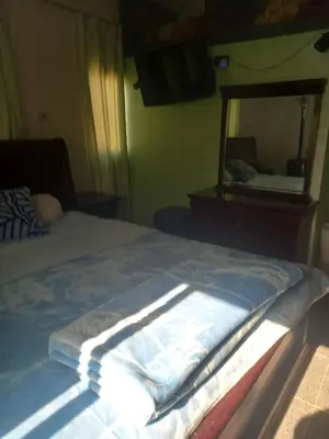 a bed in a room with a mirror at Chez La FAMILLE in Kalaat MGouna