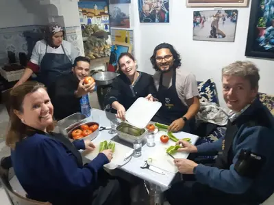 a group of people sitting around a table with vegetables at Fès Dar medina in Fès