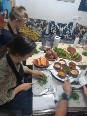 a group of women standing around a table with food at Fès Dar medina in Fès