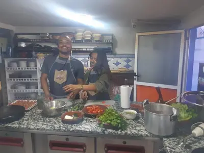 a man and woman standing in a kitchen preparing food at Fès Dar medina in Fès