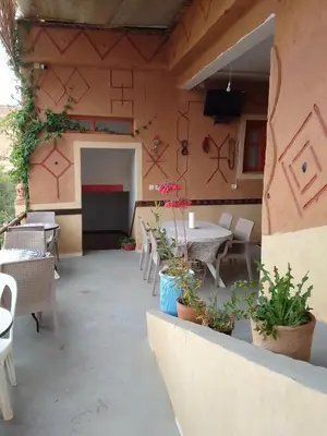 an outdoor patio with tables and chairs and plants at Ait Sedrate Tourism Cooperative Hotel in Boumalne