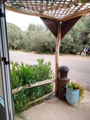 a porch with a fence and a pot of plants at Ait Sedrate Tourism Cooperative Hotel in Boumalne
