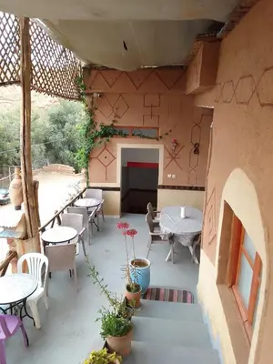 an outdoor patio with tables and tables and chairs at Ait Sedrate Tourism Cooperative Hotel in Boumalne