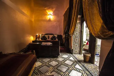a bedroom with a bed and a table in a room at Riad Famille Drissi Kaitouni in Fès