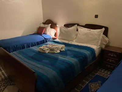 two beds in a room with towels on the bed at Riad Famille Drissi Kaitouni in Fès