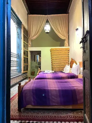 a bedroom with a purple bed with a purple blanket at Riad Famille Drissi Kaitouni in Fès