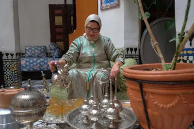 a woman is sitting in a room with some vases at Riad Famille Drissi Kaitouni in Fès