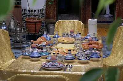 a table with blue and white china on it at Riad Famille Drissi Kaitouni in Fès