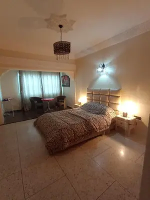 a bedroom with a large bed and a dining room at appartement splendid au centre ville in Fès
