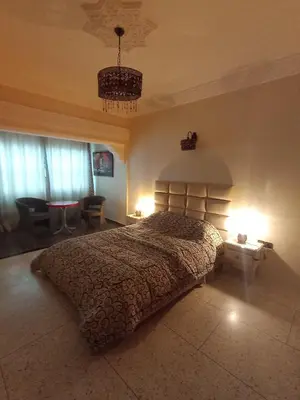 a bedroom with a large bed with two lights on at appartement splendid au centre ville in Fès